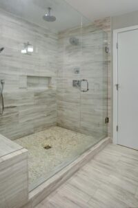 Bathroom remodel in Frisco with Marble Tile and Glass Shower Walls 